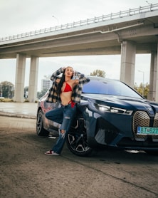 a woman in a red bikini standing next to a blue car