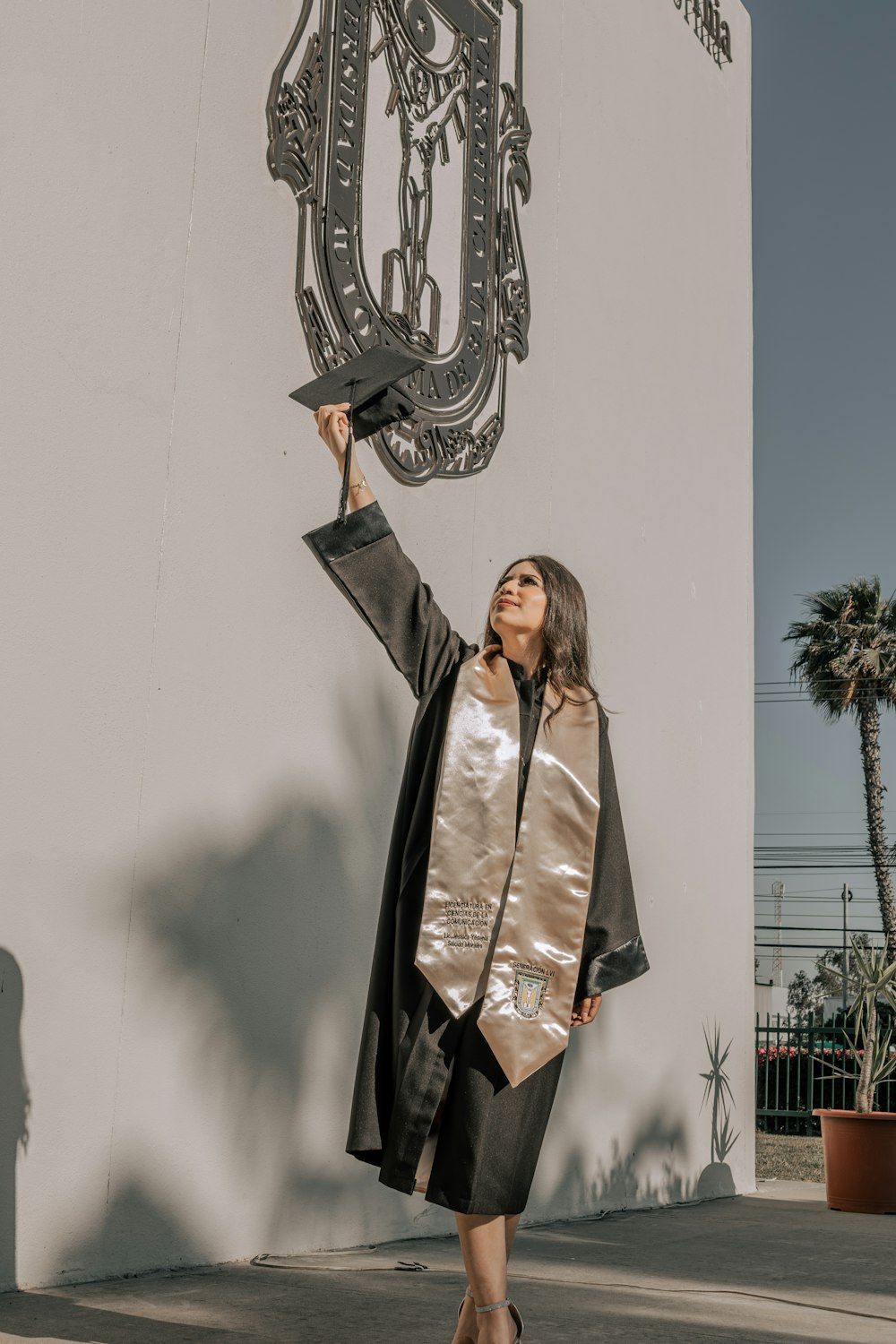 a woman standing in front of a building holding up a clock