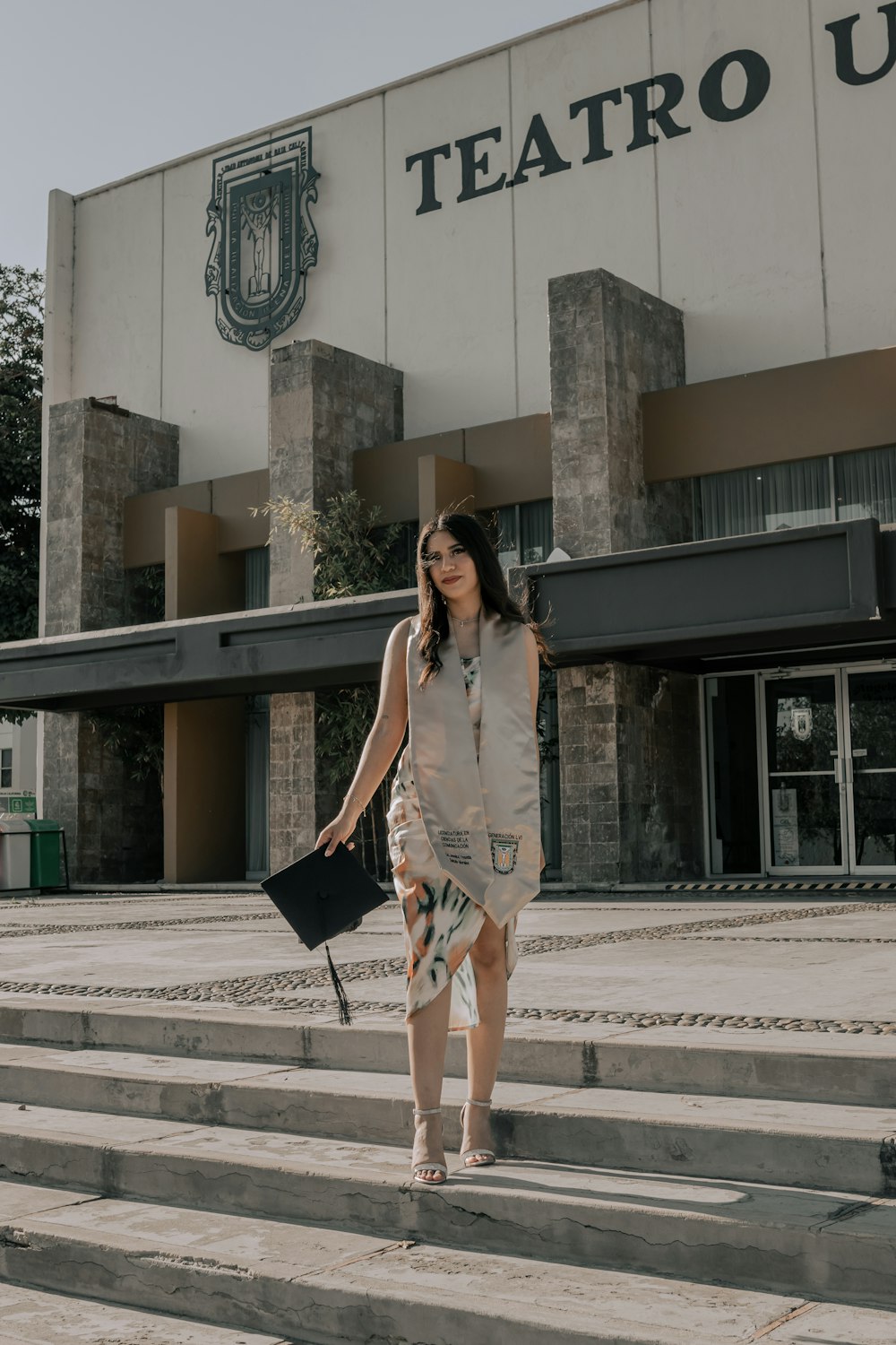 Une femme descendant quelques marches devant un immeuble