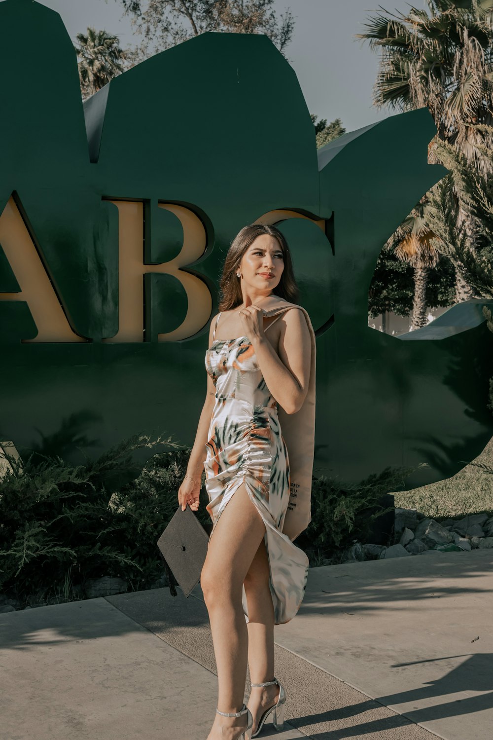 a woman in a dress standing in front of a sign