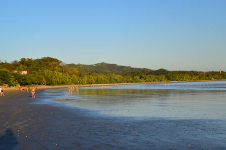 A serene beach at sunset with travelers enjoying a private guided tour.
