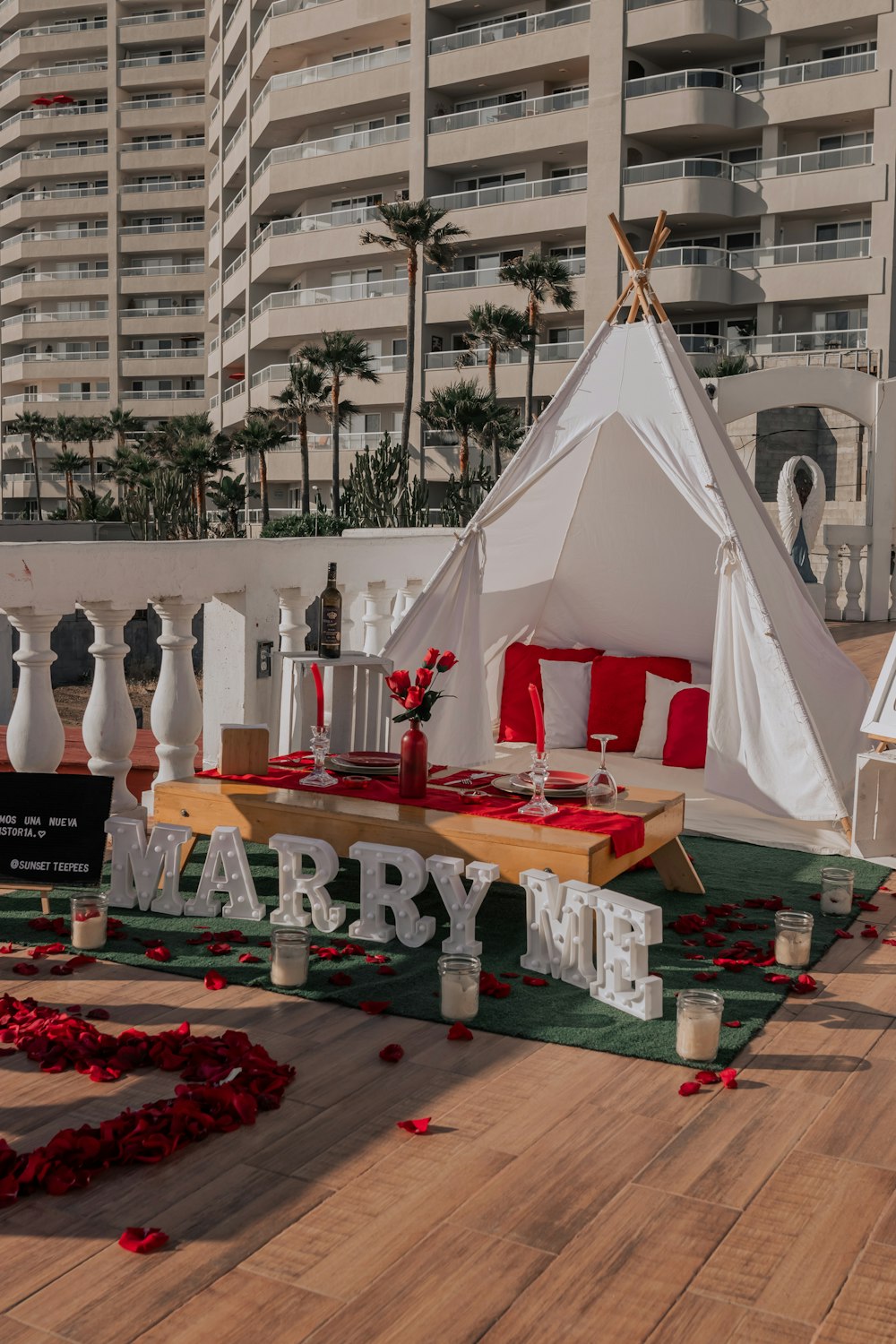 Una carpa preparada para una fiesta con pétalos de rosa roja en el suelo