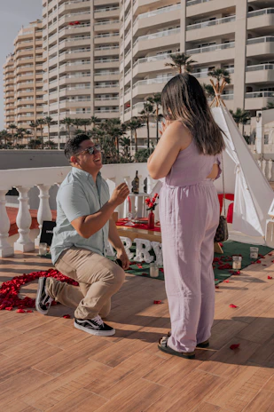 An intimate proposal moment on a rooftop terrace, featuring a sparkling engagement ring against the backdrop of iconic UAE landmarks.