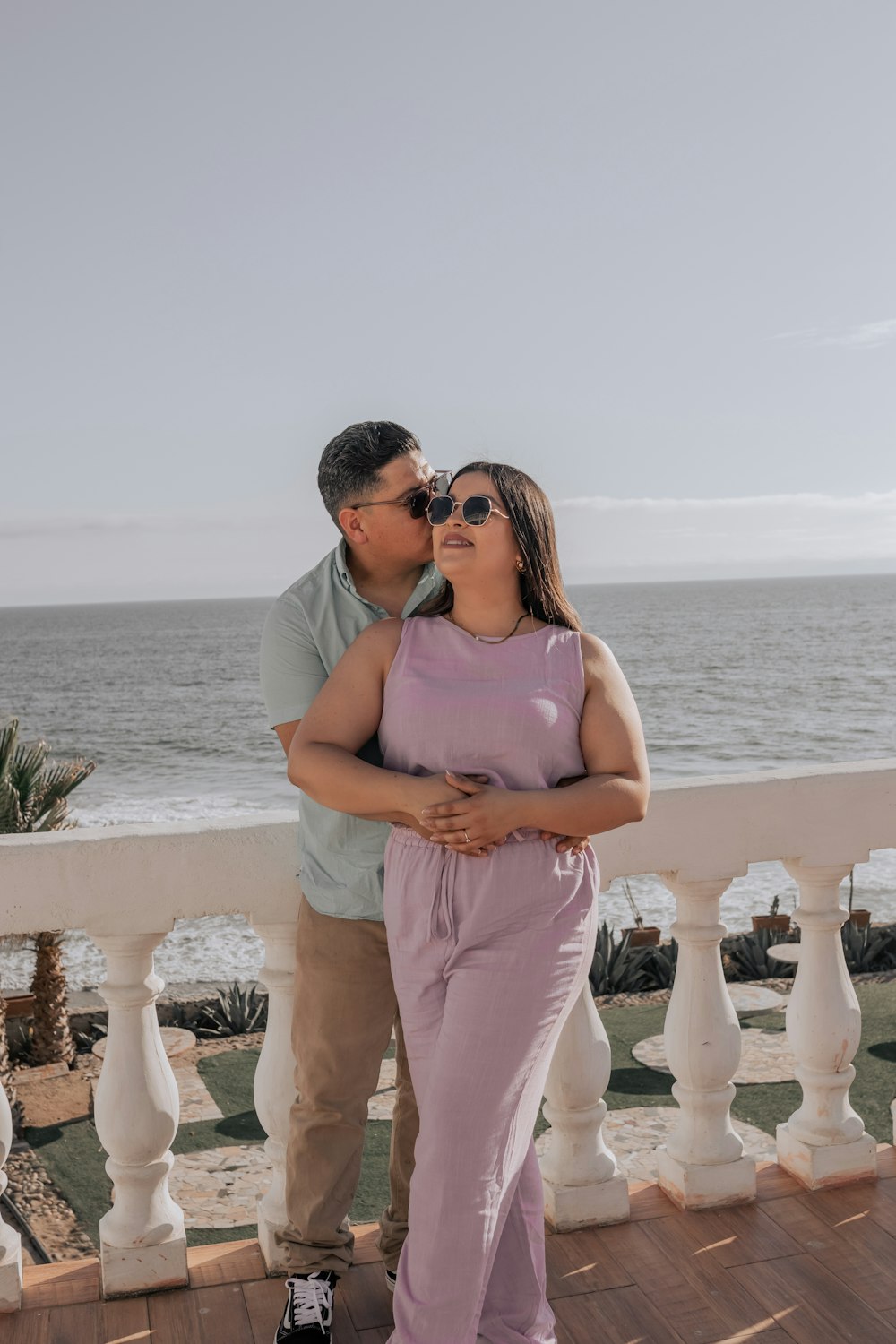 a man standing next to a woman on top of a balcony