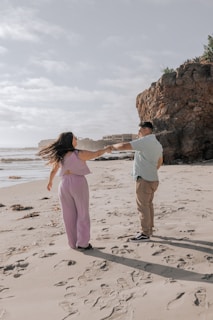 Couple dancing barefoot on a sunlit beach at golden hour