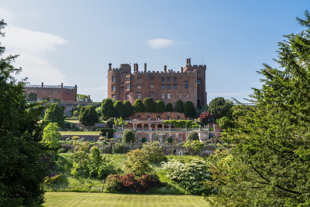 a large castle sitting on top of a lush green field