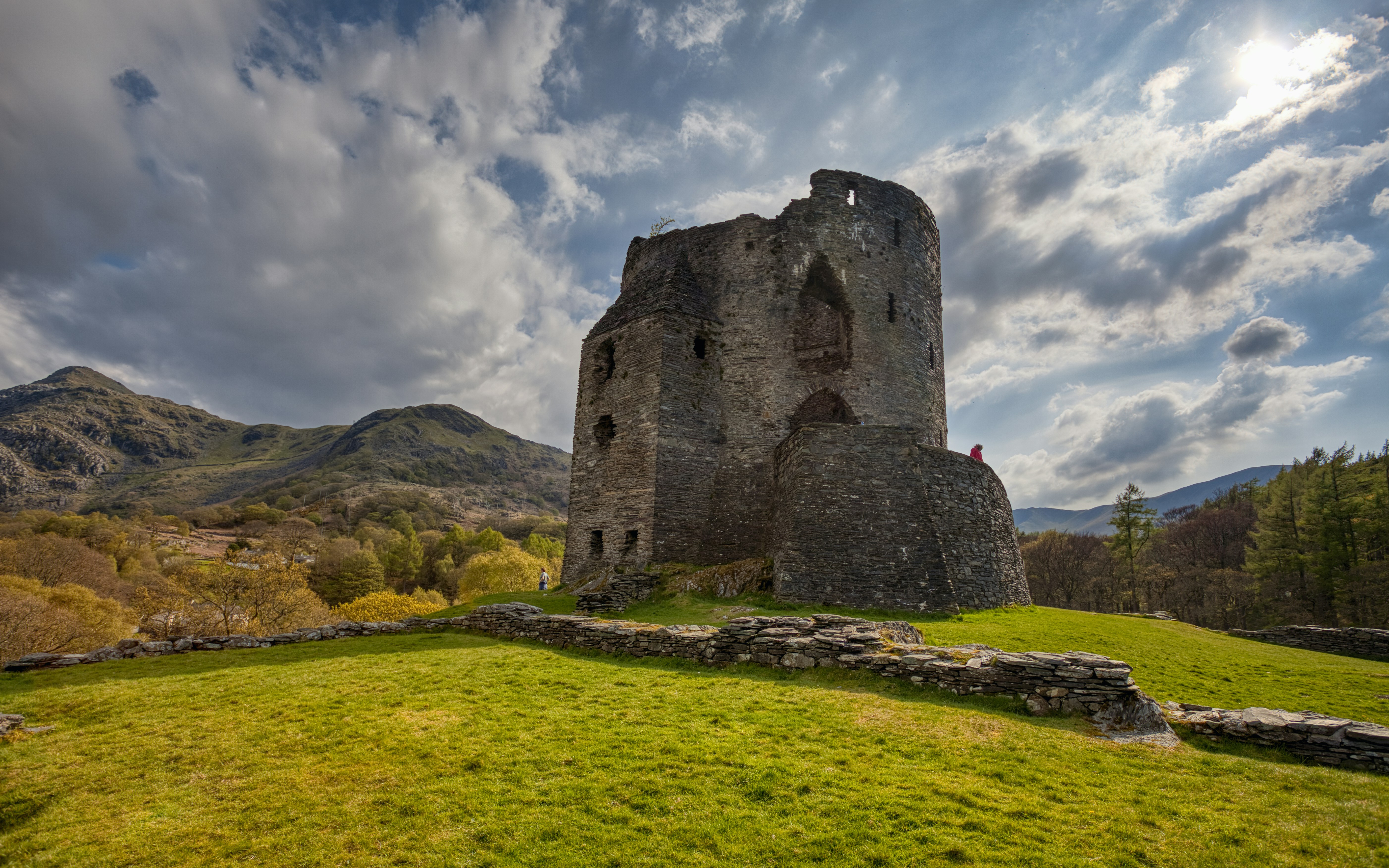 a castle sitting on top of a lush green hillside