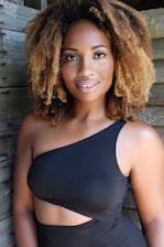 A smiling person posing naturally inside a stylish photo booth at an event.