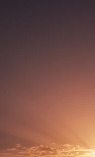 A peaceful scene of a sunset blending beige and brown hues with glowing light beams.