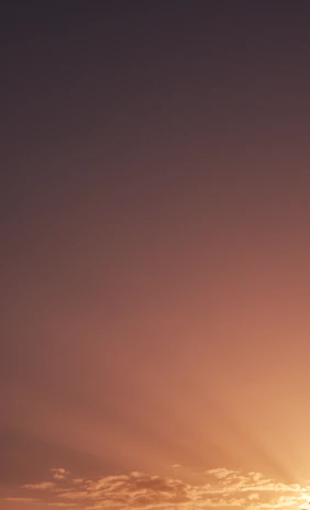 A peaceful scene of a sunset blending beige and brown hues with glowing light beams.