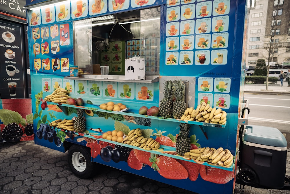 a food truck with fruit on the side of it