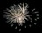 An elaborate display of fireworks with bright, white and gold sparks radiating in different directions against a dark sky.