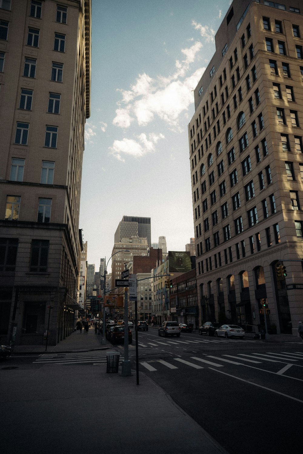 a city street lined with tall buildings under a cloudy sky