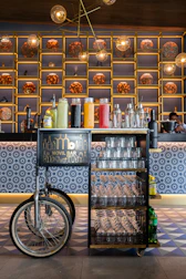 An elegant mobile bar station glowing softly under ambient lighting at a chic corporate event.
