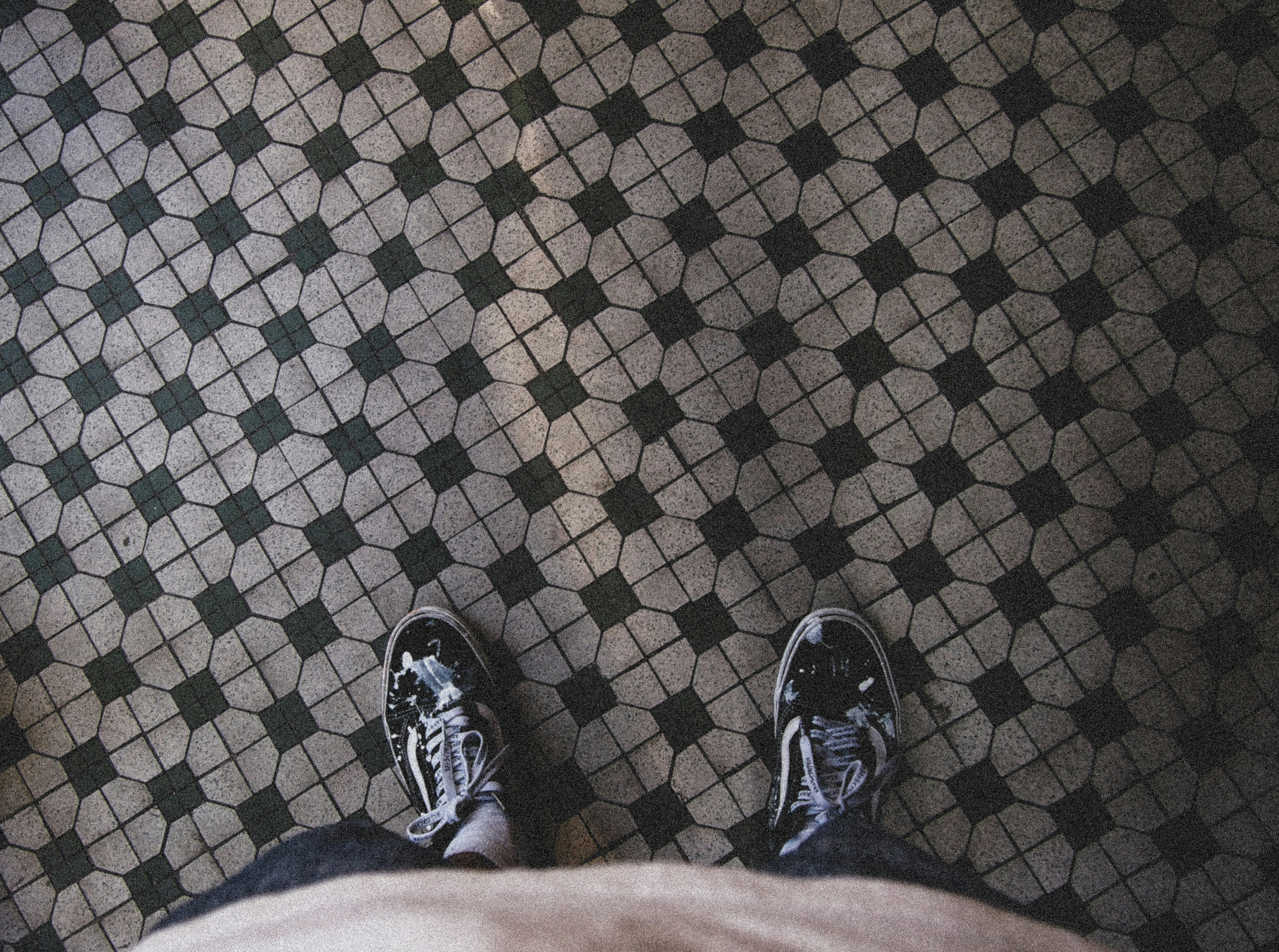 a person standing on a tiled floor with their feet up