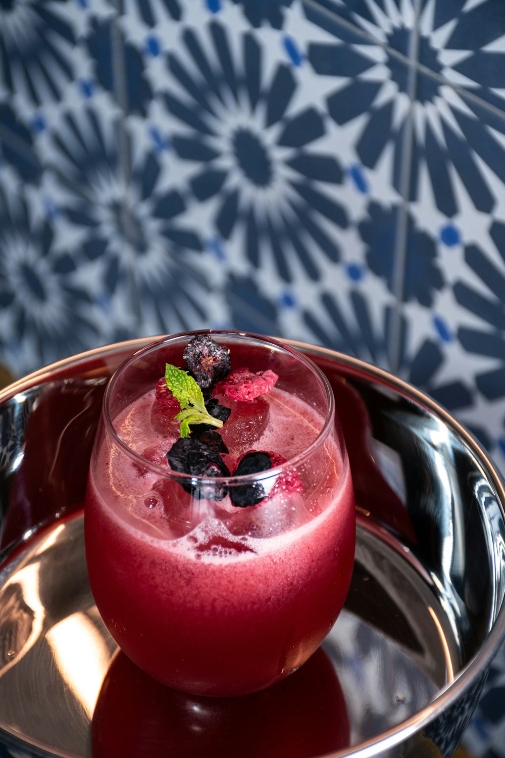 a drink in a glass on a metal tray