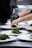 A chef arranging food on eco-friendly bagasse trays in a modern kitchen.