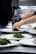 A chef arranging food on eco-friendly bagasse trays in a modern kitchen.