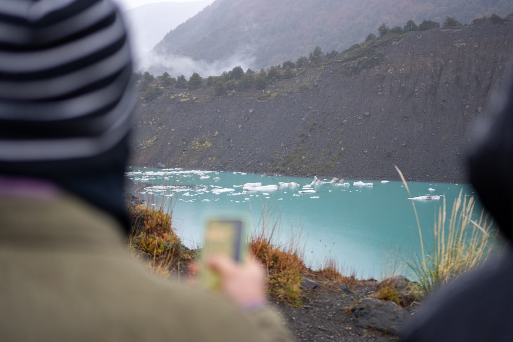 a person taking a picture of a lake