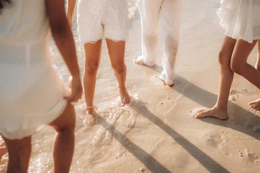 a group of people standing on top of a sandy beach