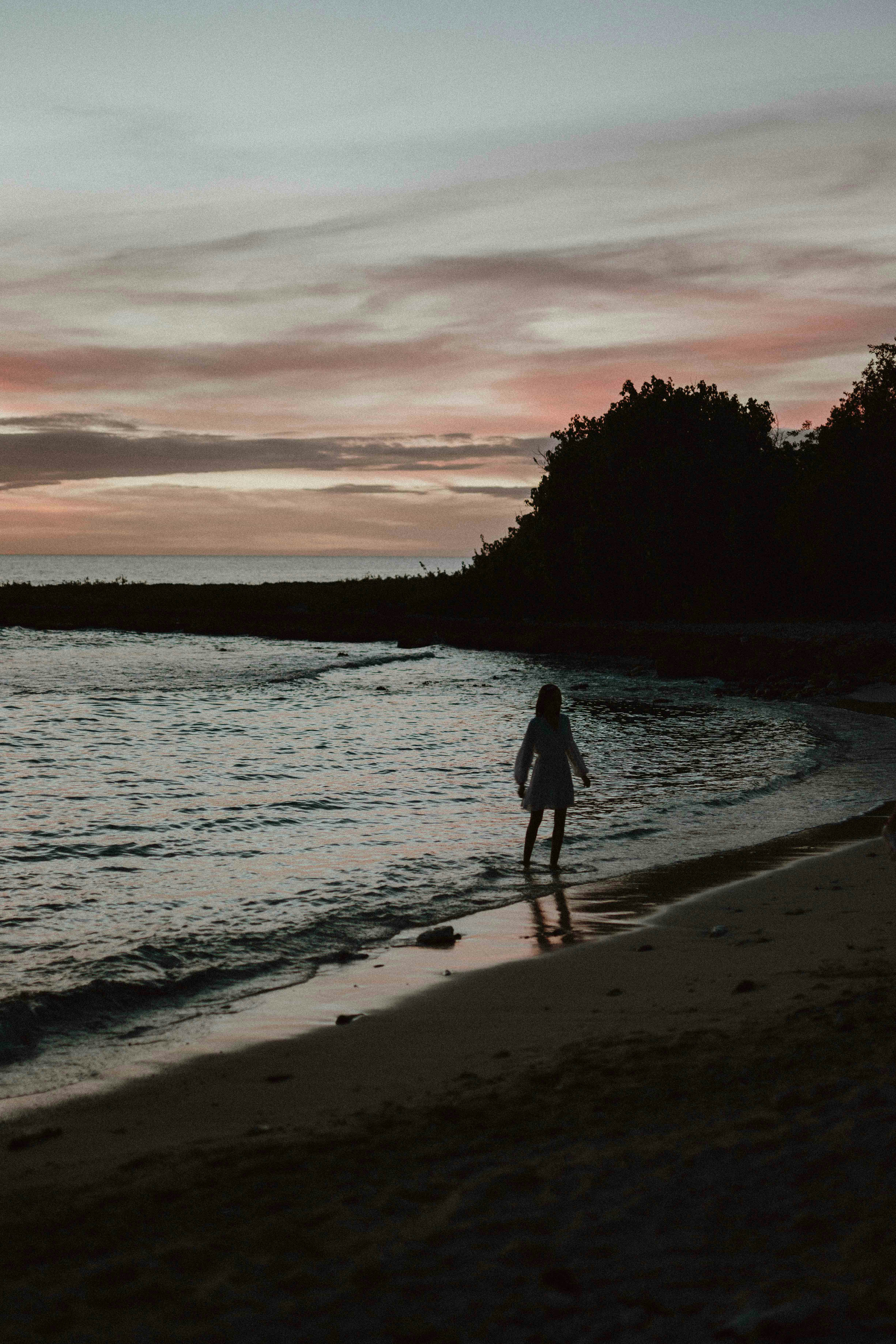 a person standing on a beach next to the ocean