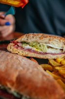 A vibrant deli sub loaded with colorful veggies, meats, and melted cheese on a fresh baguette.