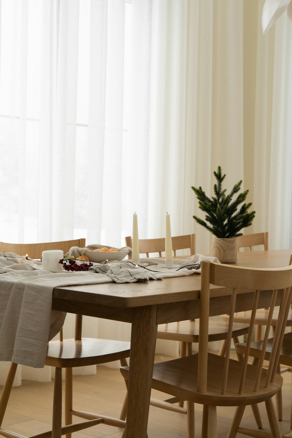 a dining room table with a christmas tree in the corner