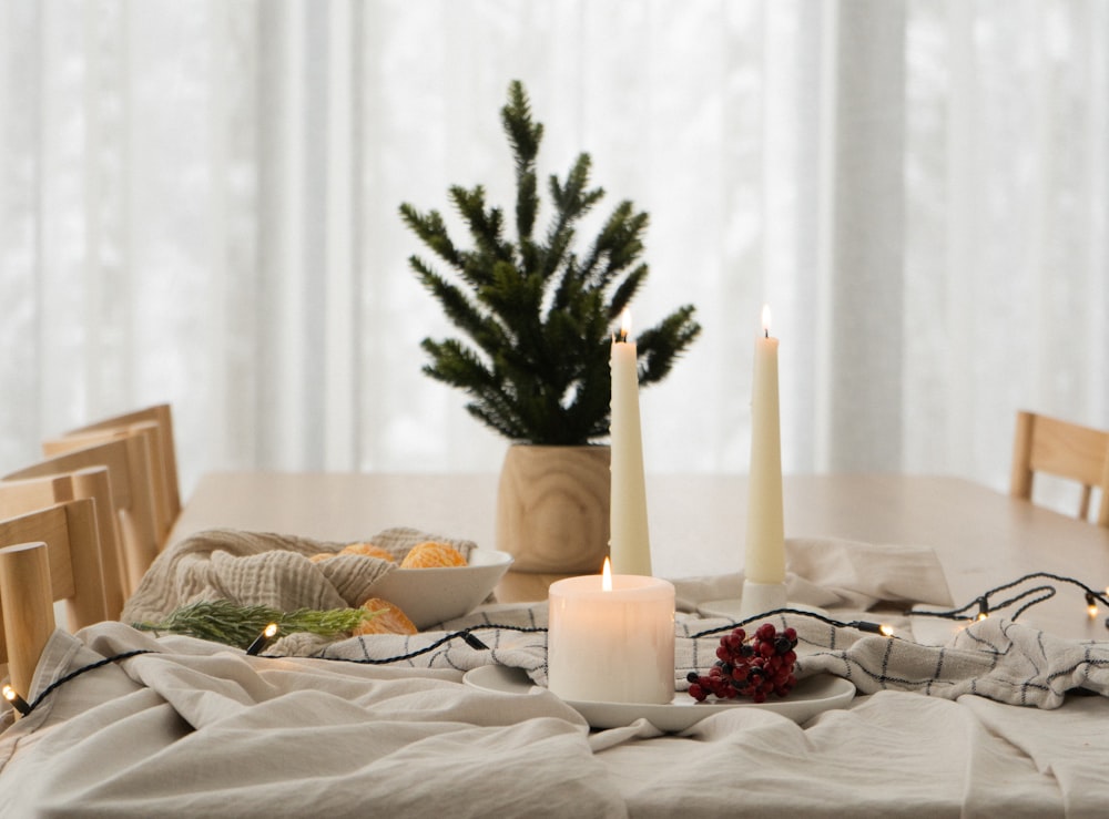 a table topped with candles and a bowl of fruit