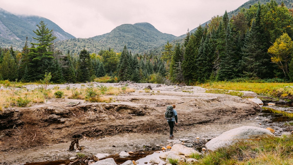 a man standing on a rocky river bank