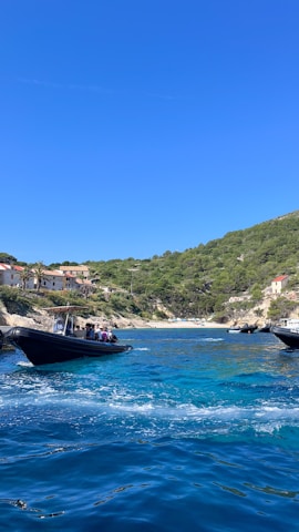 Tourists enjoying a boat ride towards the crystal-clear waters of the Rosario Islands under a bright blue sky.