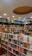 A well-organized bookstore interior with shelves full of diverse books. The sections include categories like Business & Management, Self Help, Indian Fiction, Crime & Mystery, and Bestsellers. The ceiling features recessed lighting and a circular design element.