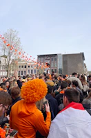 Fans cheering wildly at a celebrity meet-and-greet event, orange accents everywhere.