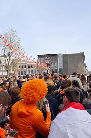 Fans cheering wildly at a celebrity meet-and-greet event, orange accents everywhere.