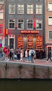 a group of people walking across a bridge over a river