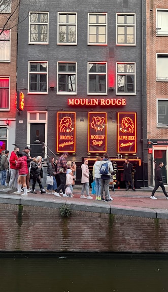 a group of people walking across a bridge over a river