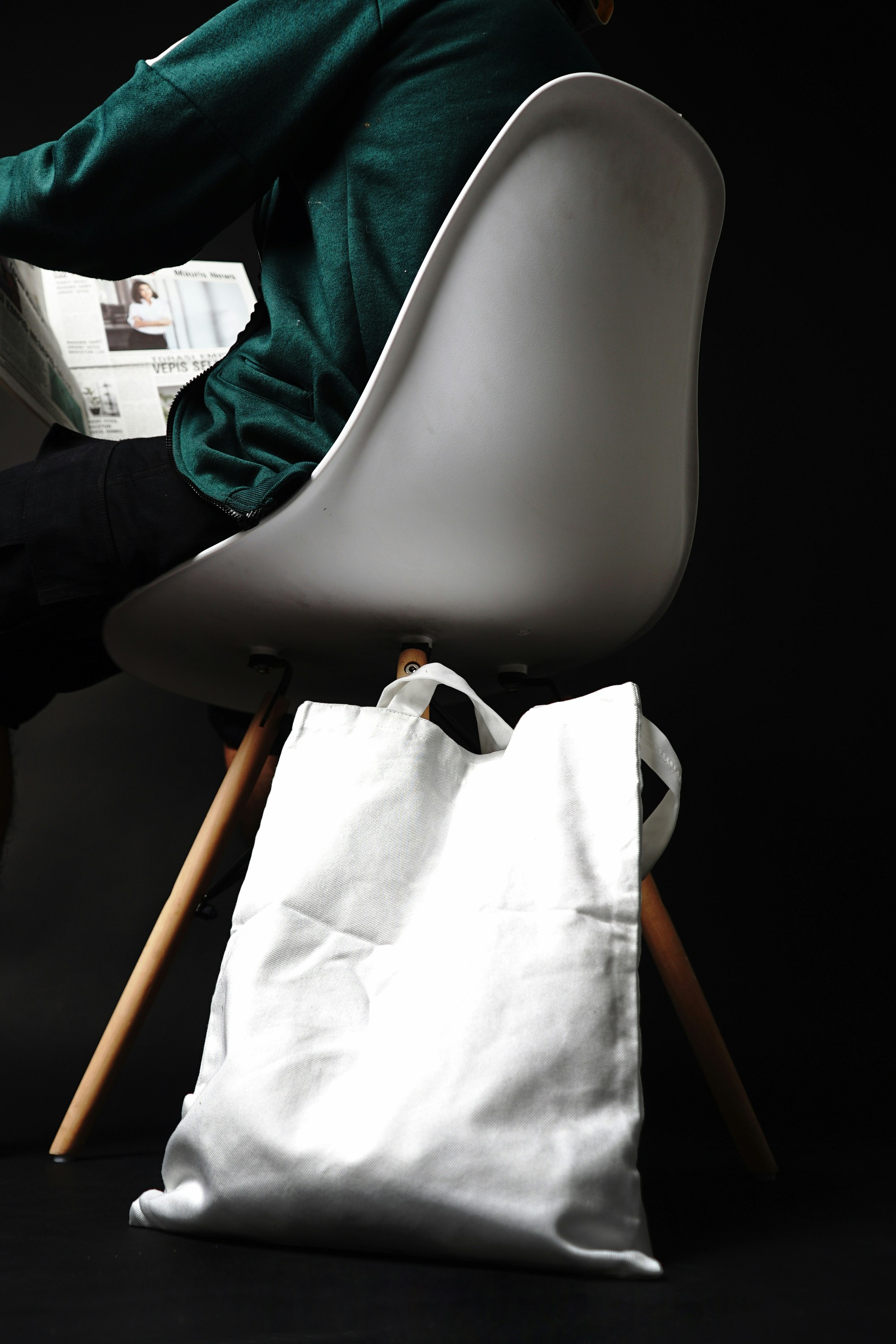 a person sitting on a chair reading a magazine