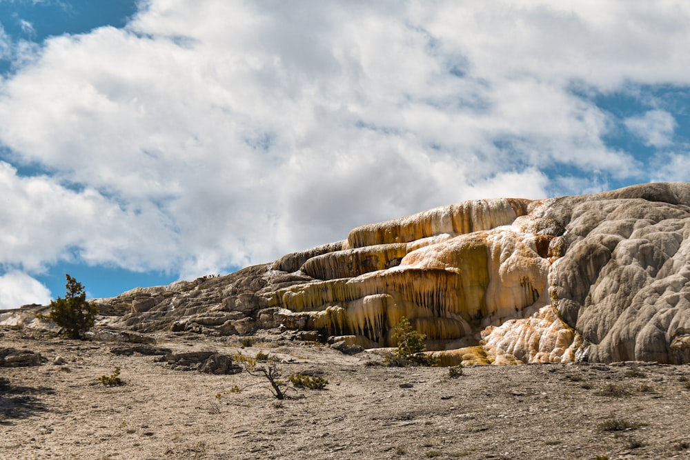 Un affleurement rocheux dans le désert sous un ciel bleu nuageux