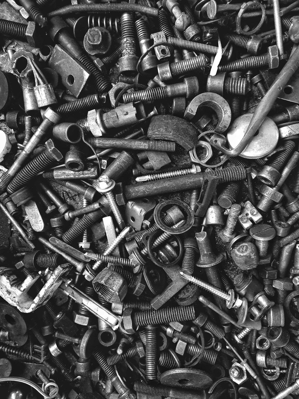 a pile of screws and nuts in black and white