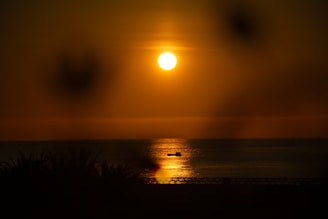Sunset view from a boat deck with warm golden light reflecting on the sea