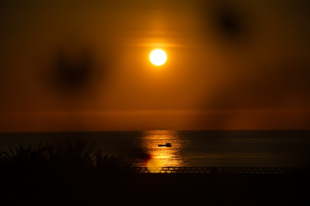 Sunset view from a boat deck with warm golden light reflecting on the sea