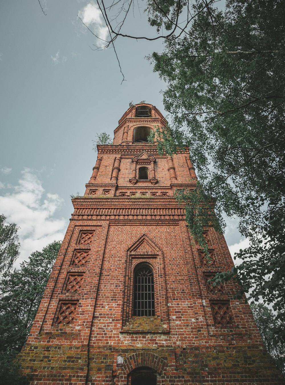 Ein hoher Backsteinturm mit einer Uhr an der Seite