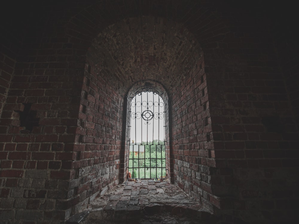 a window in a brick wall with bars on it