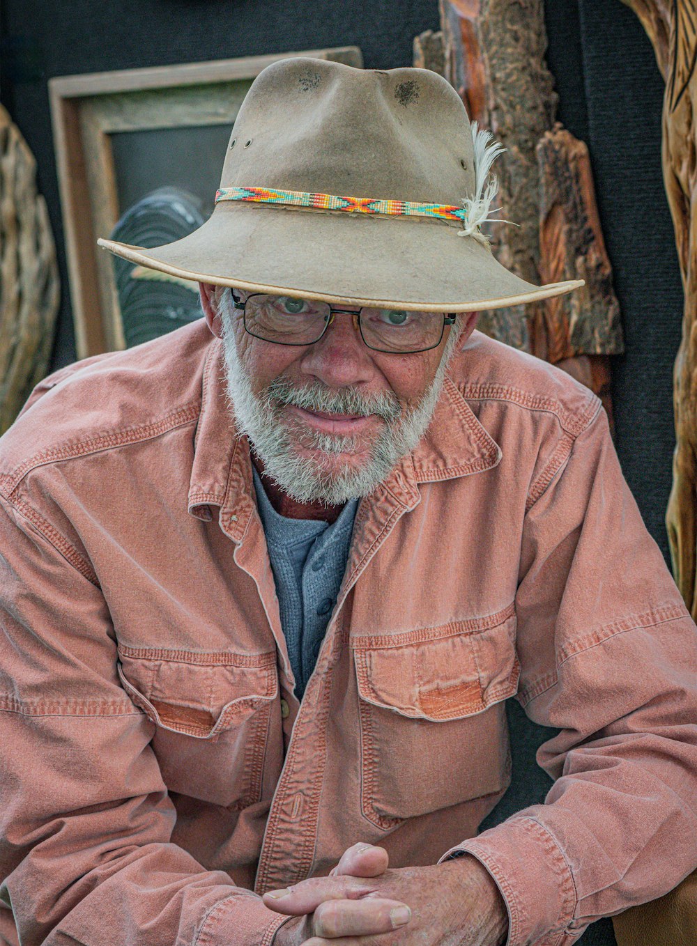 a man wearing a hat and glasses sitting down