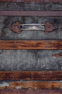 A rustic wooden trunk with metal accents, showing signs of age and use