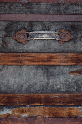 A close-up of a weathered leather steamer trunk with brass clasps resting on aged parchment.