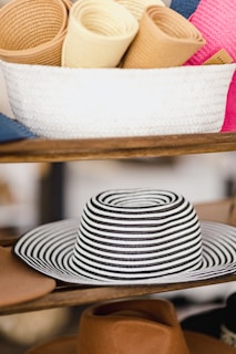 Handwoven hemp hats stacked beside a basket filled with freshly harvested hemp fibers.