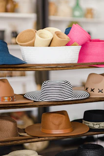 A close-up of three stylish hats displayed on rustic wooden shelves, each with unique textures and colors.