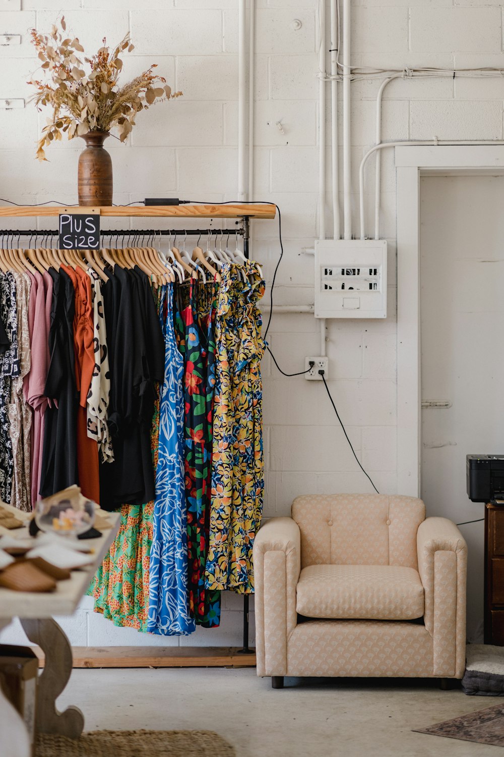 a room with a chair and a rack of clothes