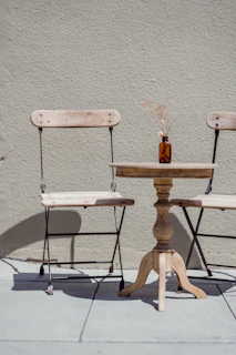 Close-up of a velora metal frame dining chair set around a rustic wooden table.