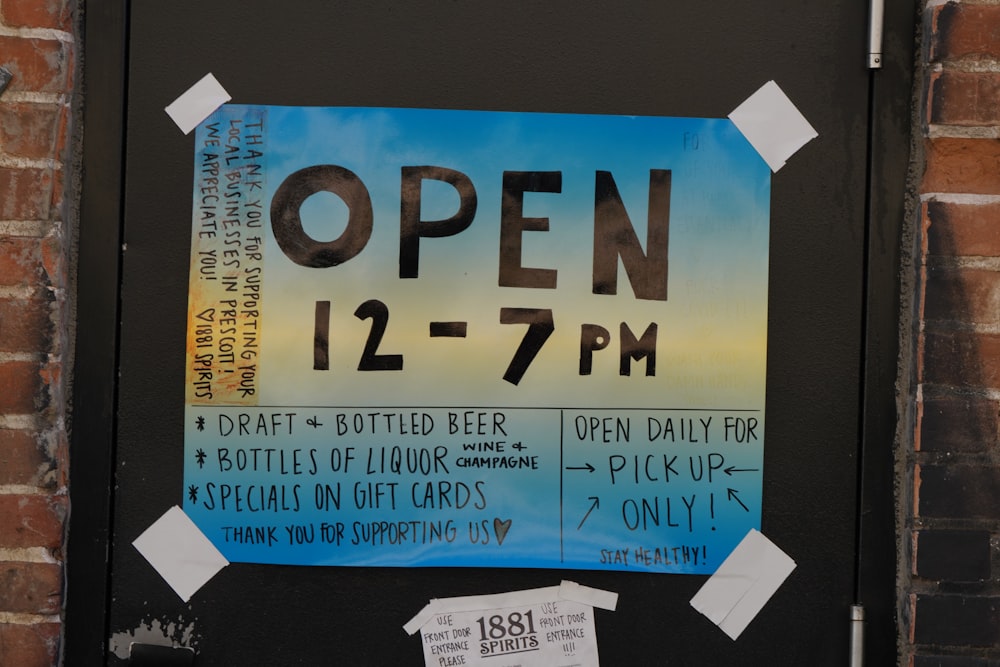a sign on a door that says open 12 - 7pm